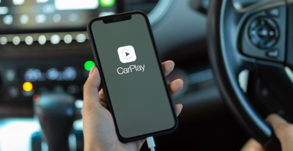 hand holding smartphone with CarPlay application. CarPlay is a