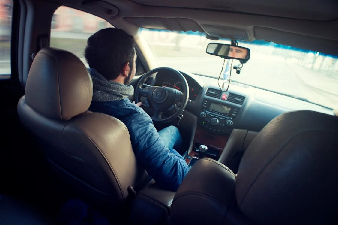 A man driving a car with both hands on the steering wheel.